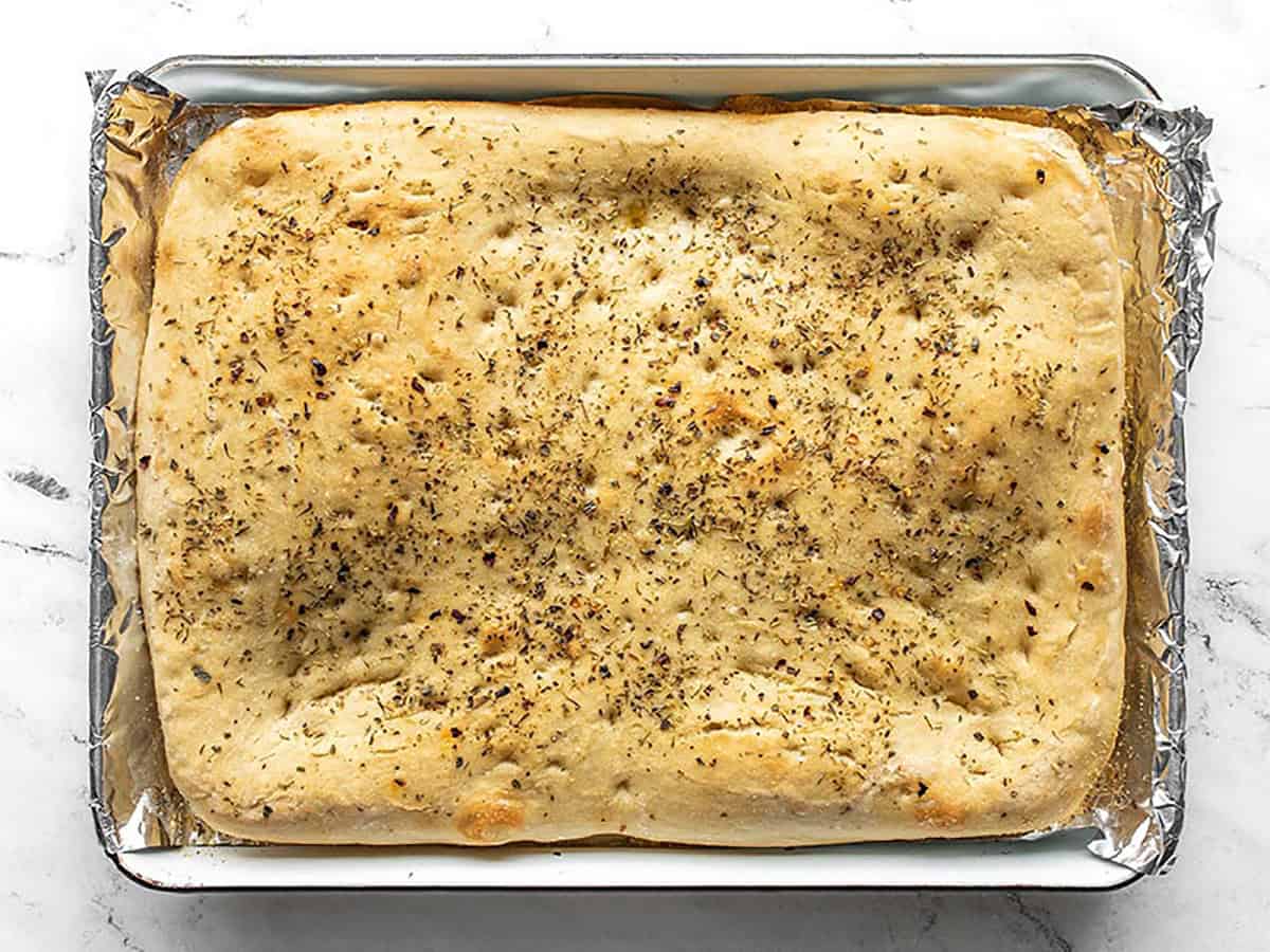 Baked focaccia bread in the baking sheet.