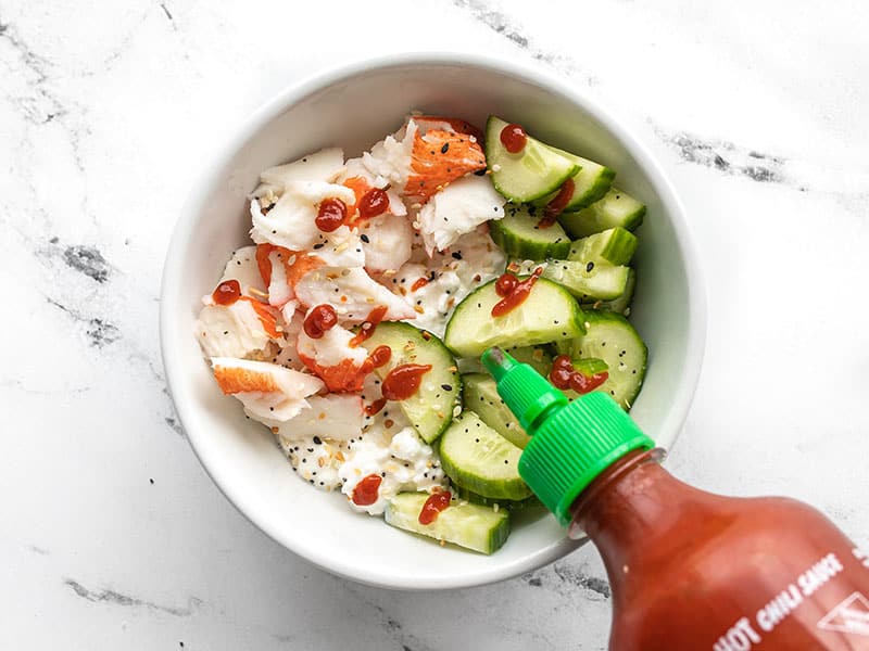 https://metabolic-life.news/wp-content/uploads/2020/05/Cottage-Cheese-Crab-Bowls-PIN2.jpg cottage cheese crab bowl being drizzled with sriracha