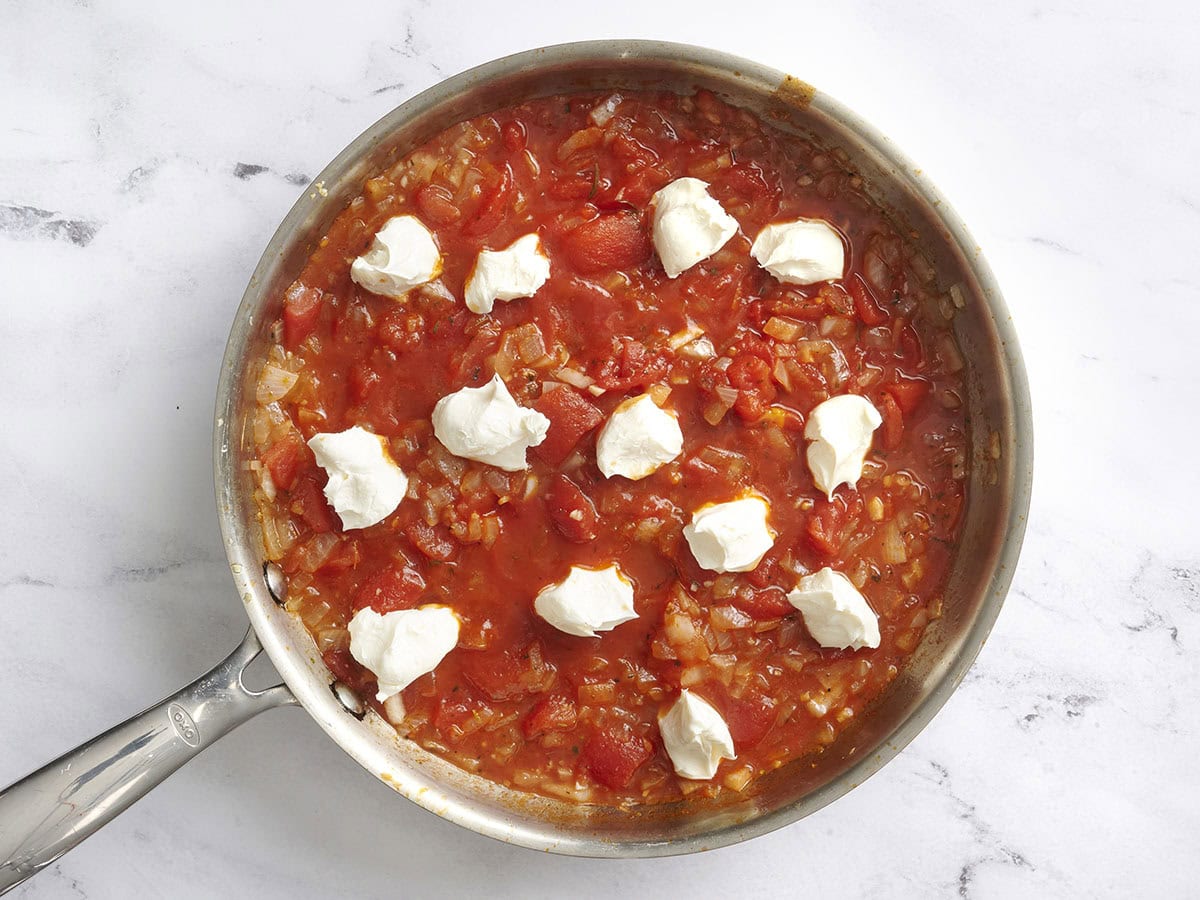 Cream cheese added to a homemade tomato sauce to make the sauce for creamy spinach pasta.