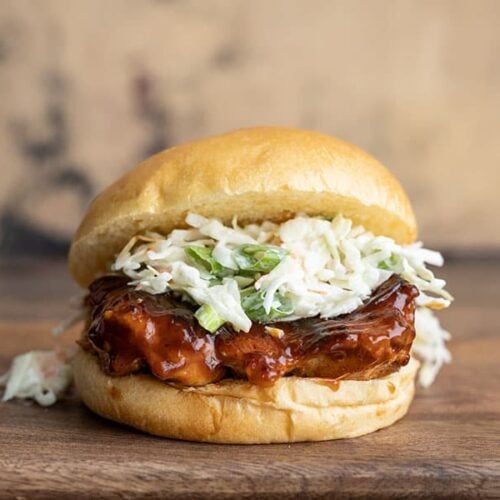 Front view of a single Easy BBQ Chicken Sandwich on a wooden cutting board
