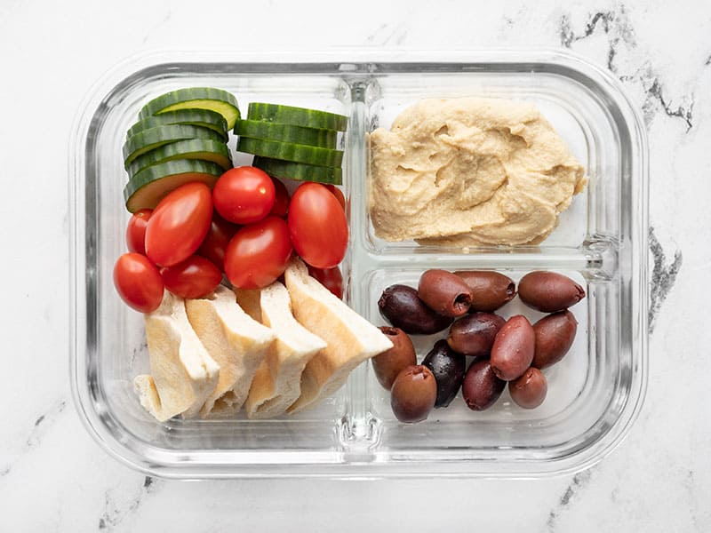 This Hummus Lunch Box is a cold lunch classic. With almost zero prep work, this is the fastest, easiest no-cook lunch around. Budgetbytes.com Overhead view of one hummus lunch box.