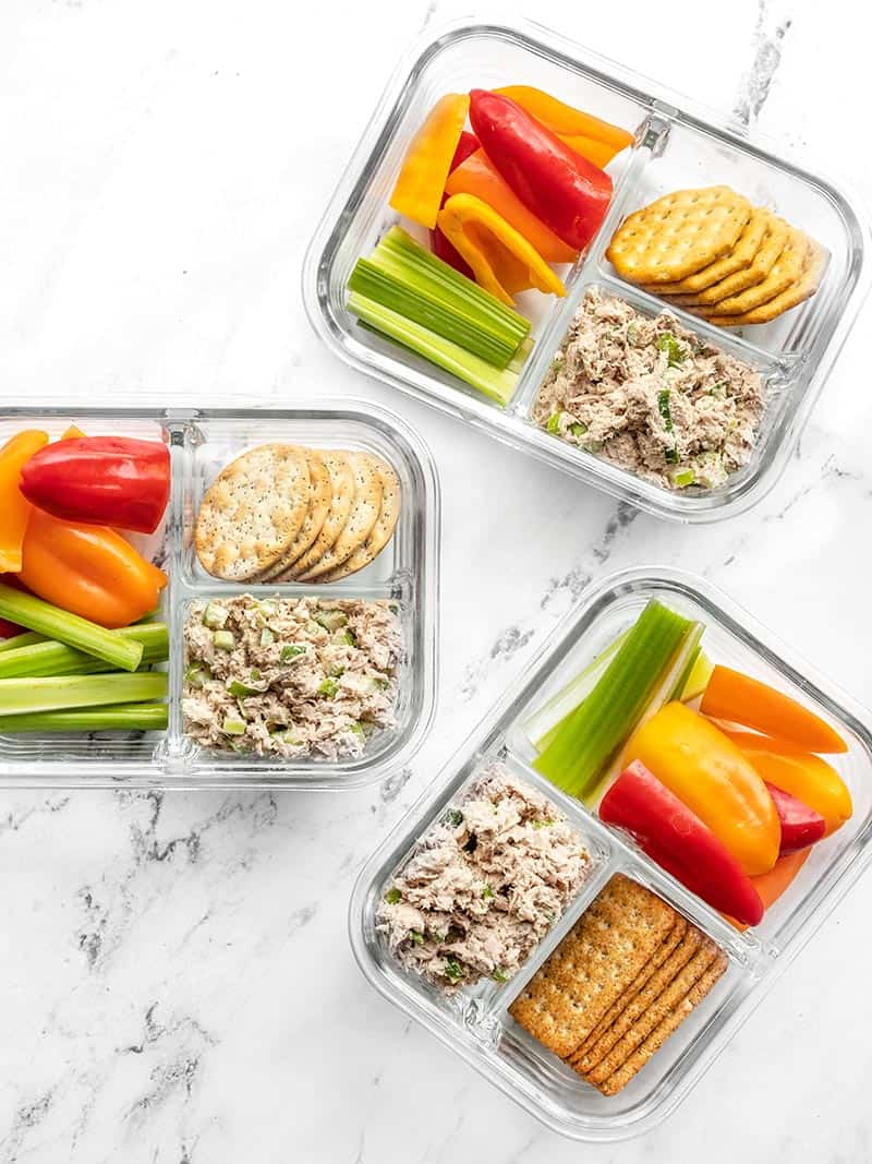 This Tuna Salad Lunch Box is an easy make-ahead lunch idea with plenty of vegetables and protein to keep you full. Budgetbytes.com Three glass containers of the tuna salad lunch box scattered