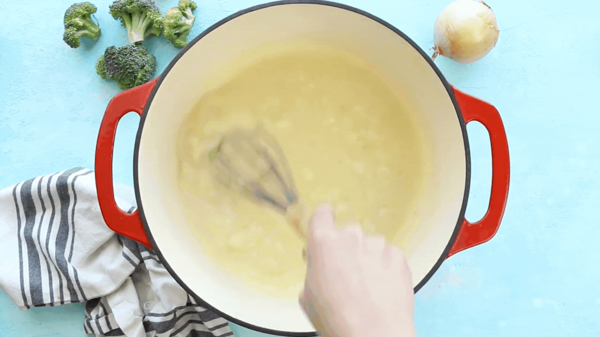 A video GIF showing milk and seasonings being added to a pot of thickened chicken broth.