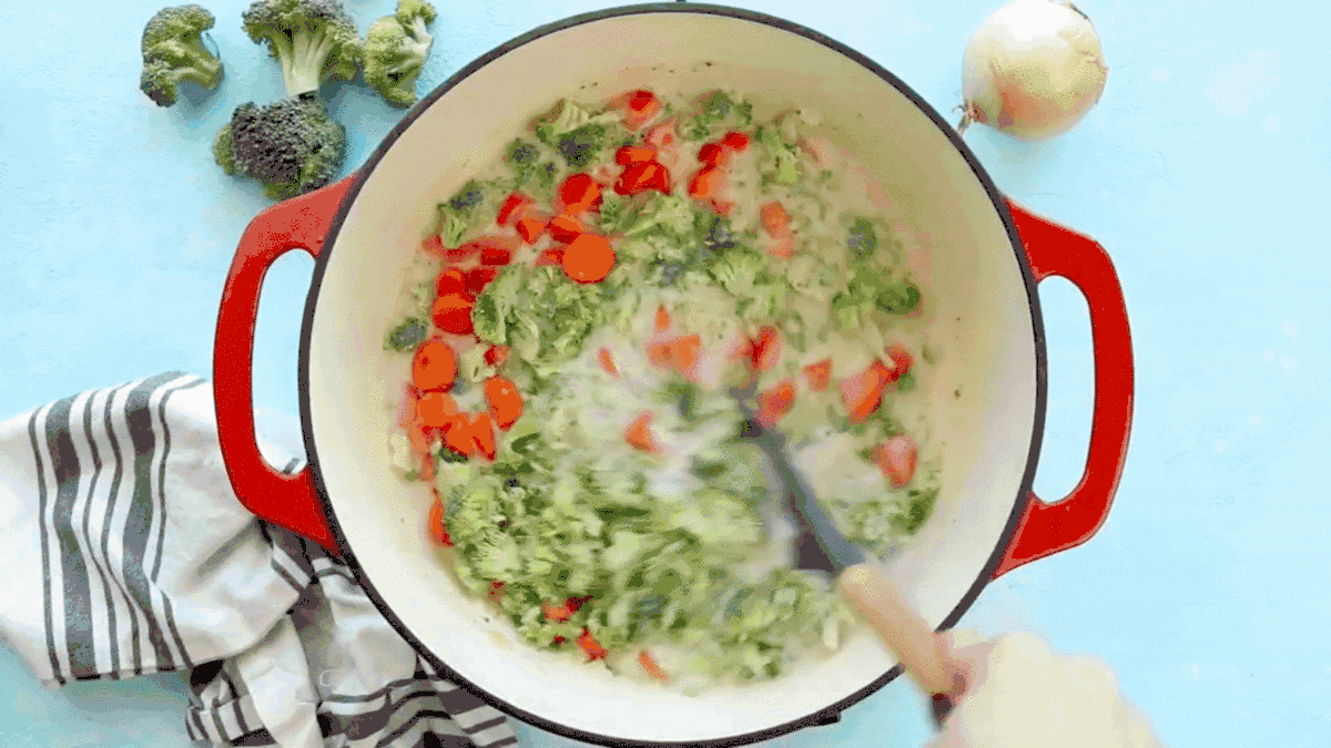 A video GIF showing broccoli cheddar soup being stirred and then simmered.