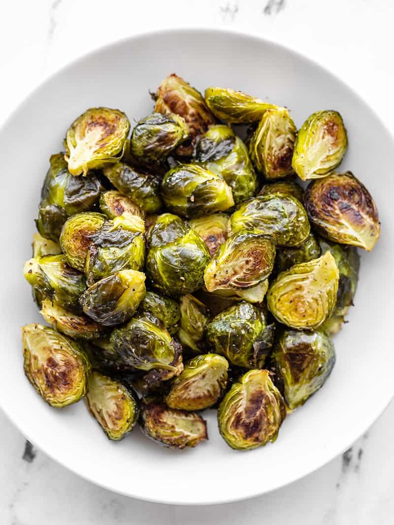 Roasted Brussels sprouts and an easy, tasty, and versatile side dish to compliment any of your fall or winter meals. Budgetbytes.com Overhead shot of a bowl of roasted Brussels sprouts