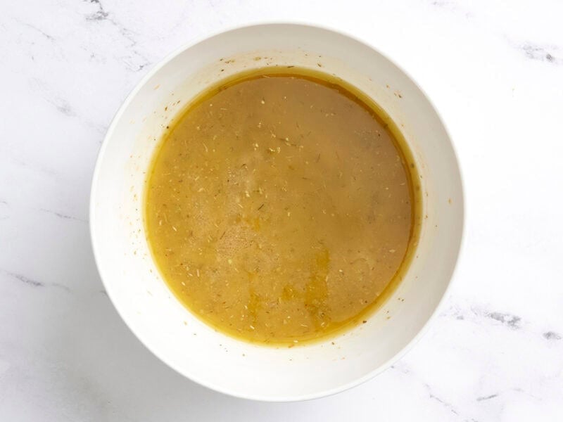 A homemade vinaigrette for summer pasta salad in a bowl.