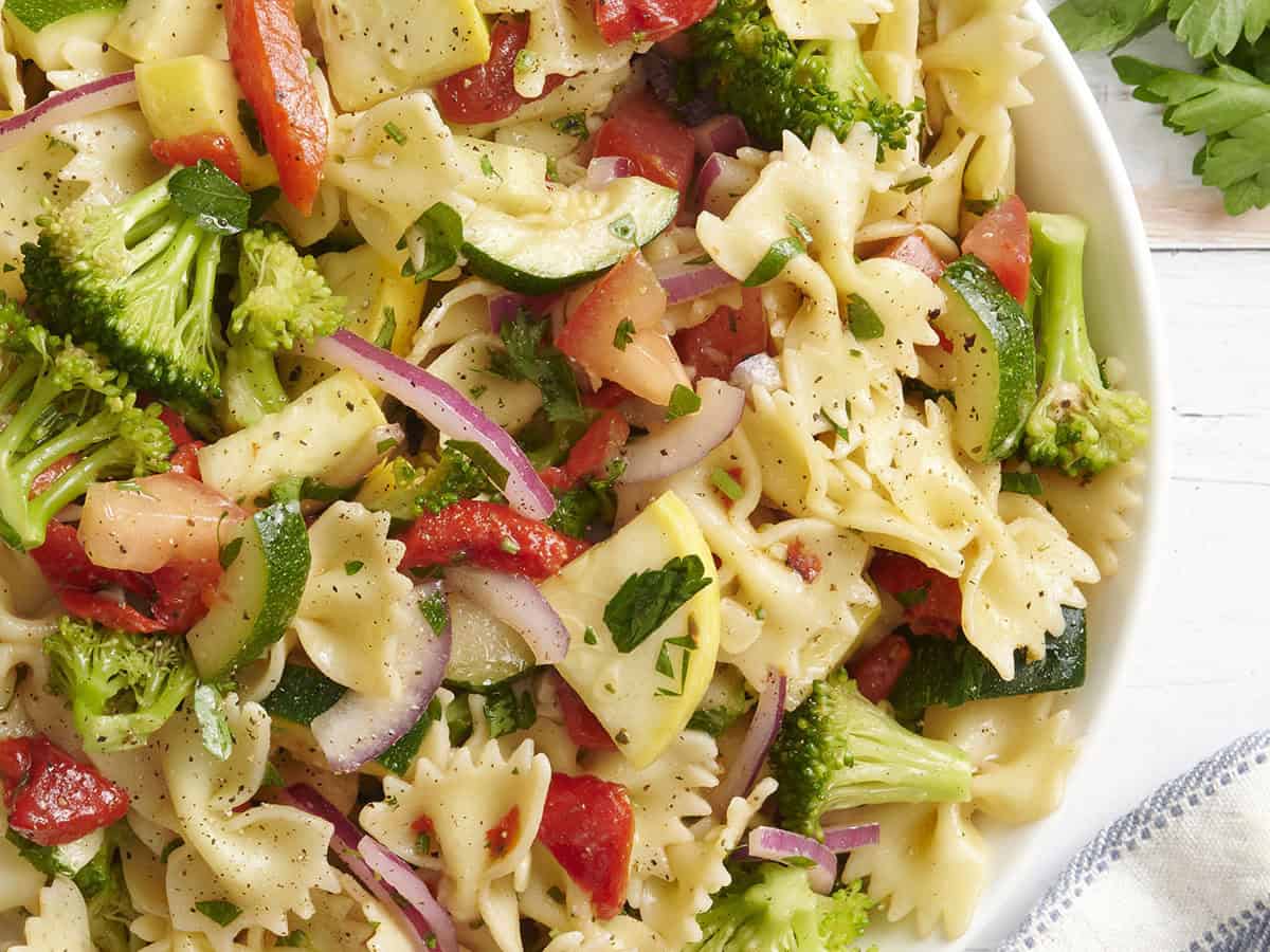 Overhead close up view of a bowl of summer vegetable pasta salad.