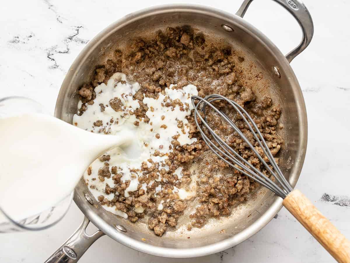Milk being whisked into the skillet