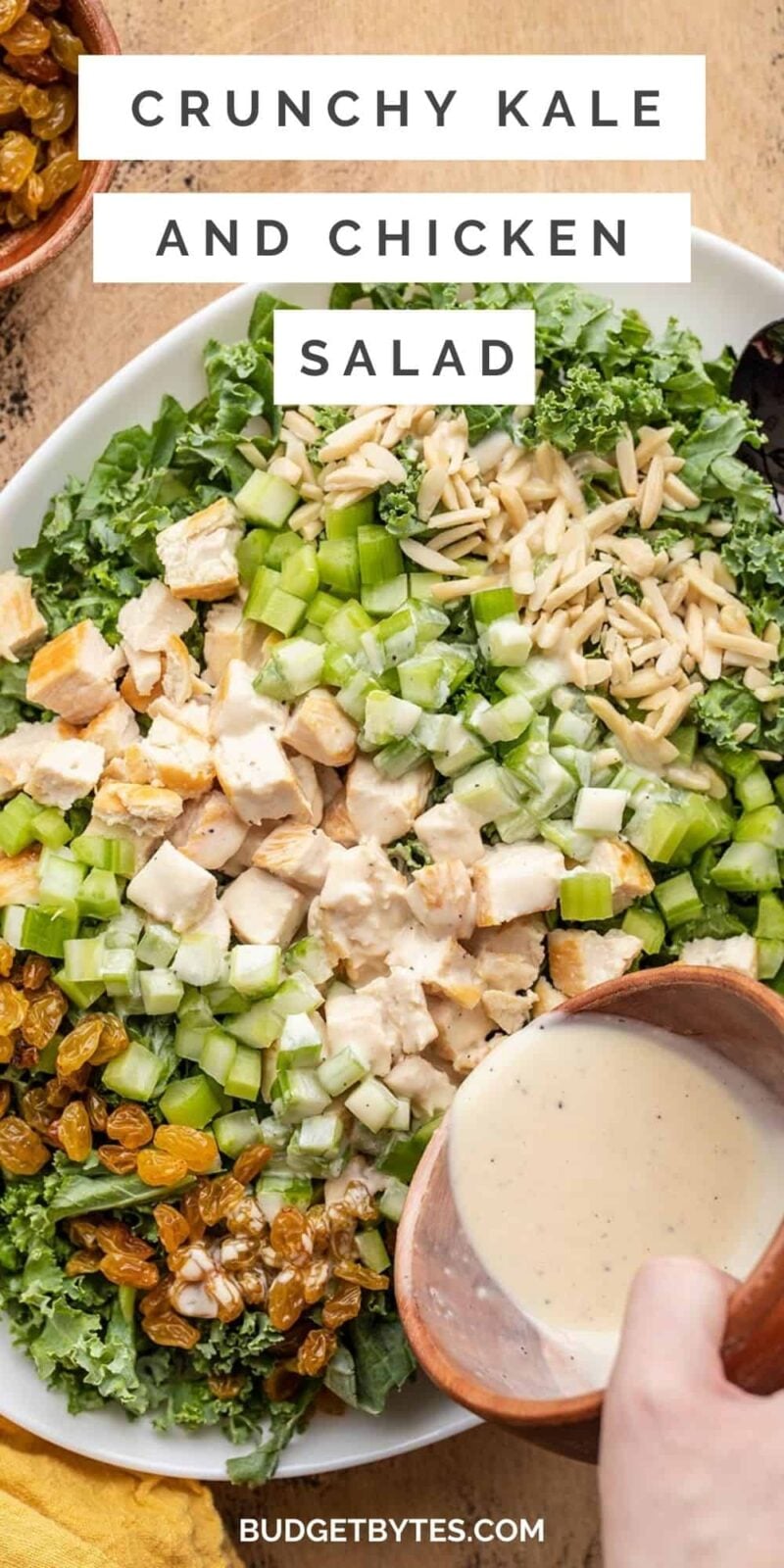 Close up of dressing being poured over kale and chicken salad, title text at the top