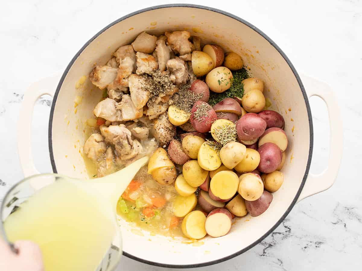 Chicken, potatoes, herbs, broth added to the pot.