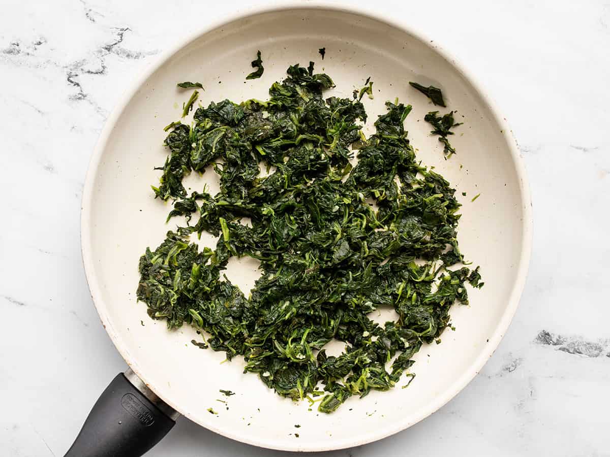 Cooked spinach in a skillet.