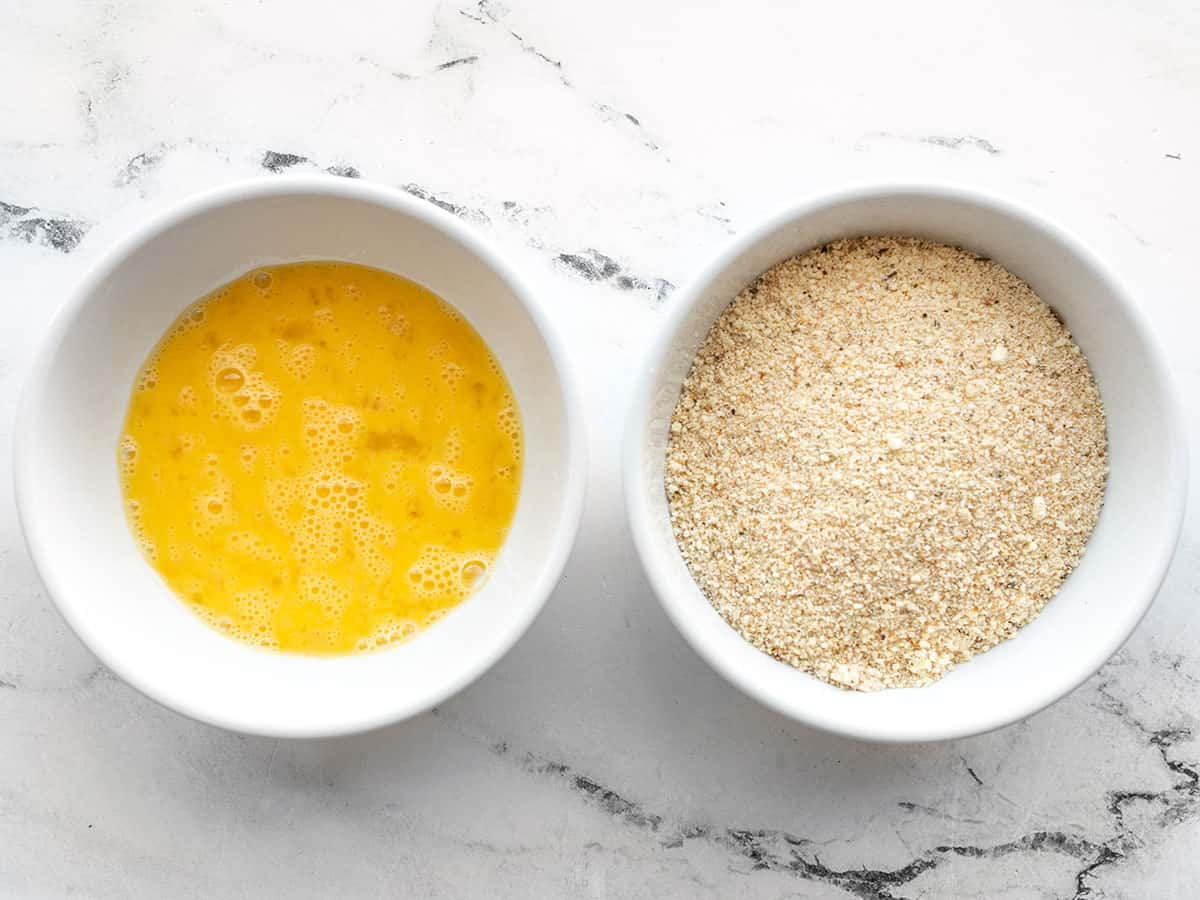 Whisked egg in a bowl and breadcrumb mixture in a bowl.