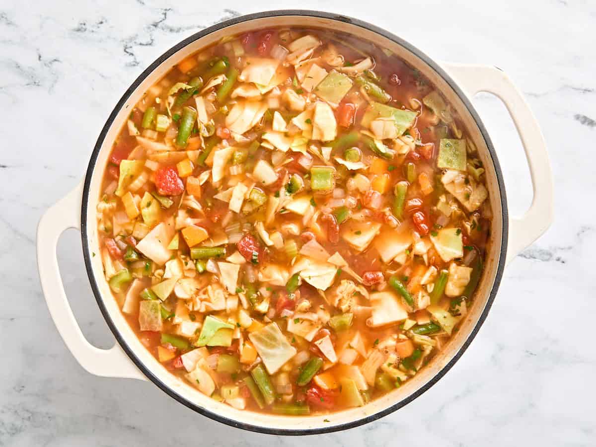 Cabbage soup in a soup pot before simmering.
