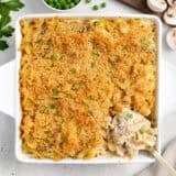 Overhead view of tuna noodle casserole in a casserole dish with a serving spoon.