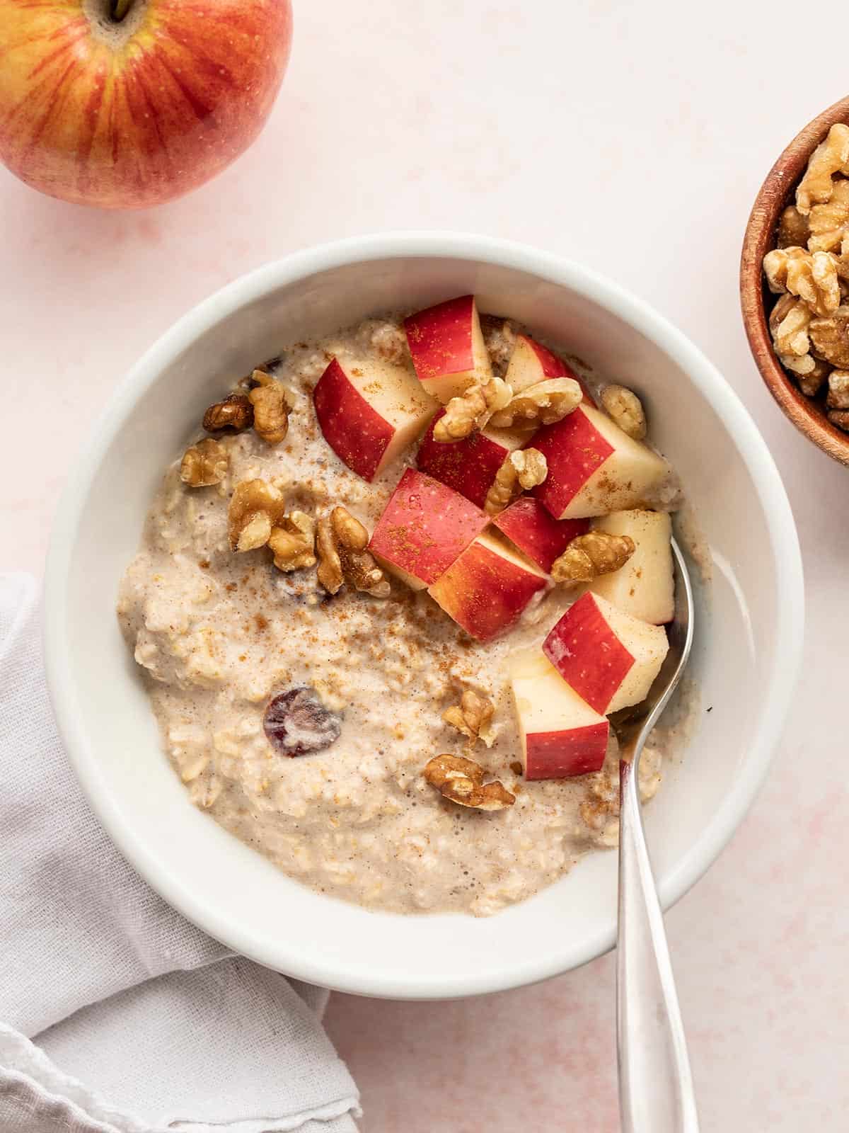 Overhead view of a bowl of apple pie overnight oats with chopped apples on top.