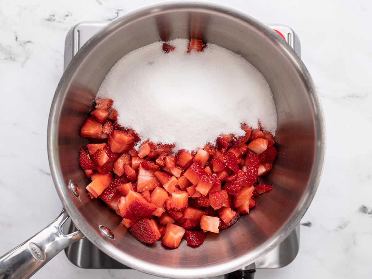 Chopped strawberries and sugar in a saucepot.