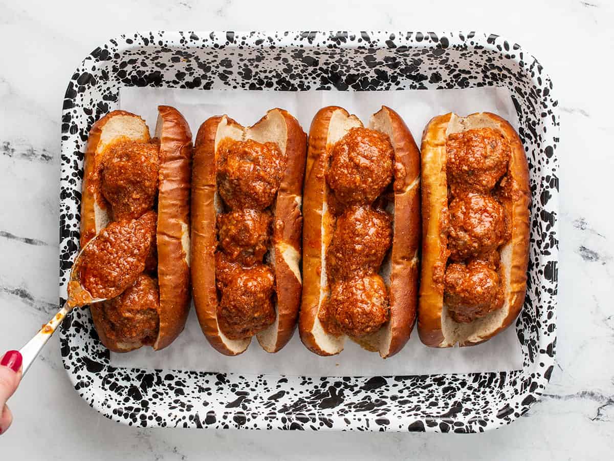 Meatballs in subs buns in a baking dish.