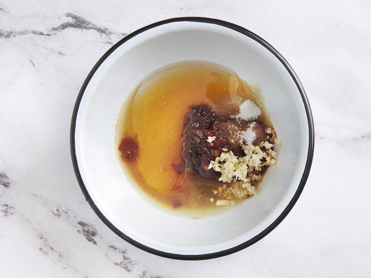 Honey, lime juice, minced garlic, salt, and cooking oil in a bowl with minced chipotle peppers.