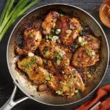 Overhead view of one skillet chipotle honey chicken topped with green onions.