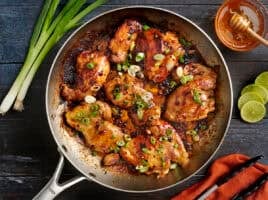 Overhead view of one skillet chipotle honey chicken topped with green onions.