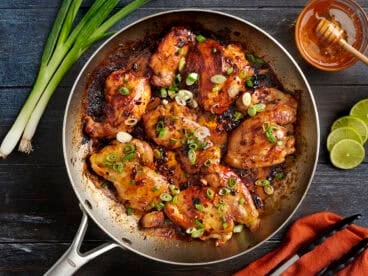 Overhead view of one skillet chipotle honey chicken topped with green onions.