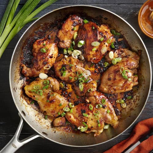 Overhead view of one skillet chipotle honey chicken topped with green onions.