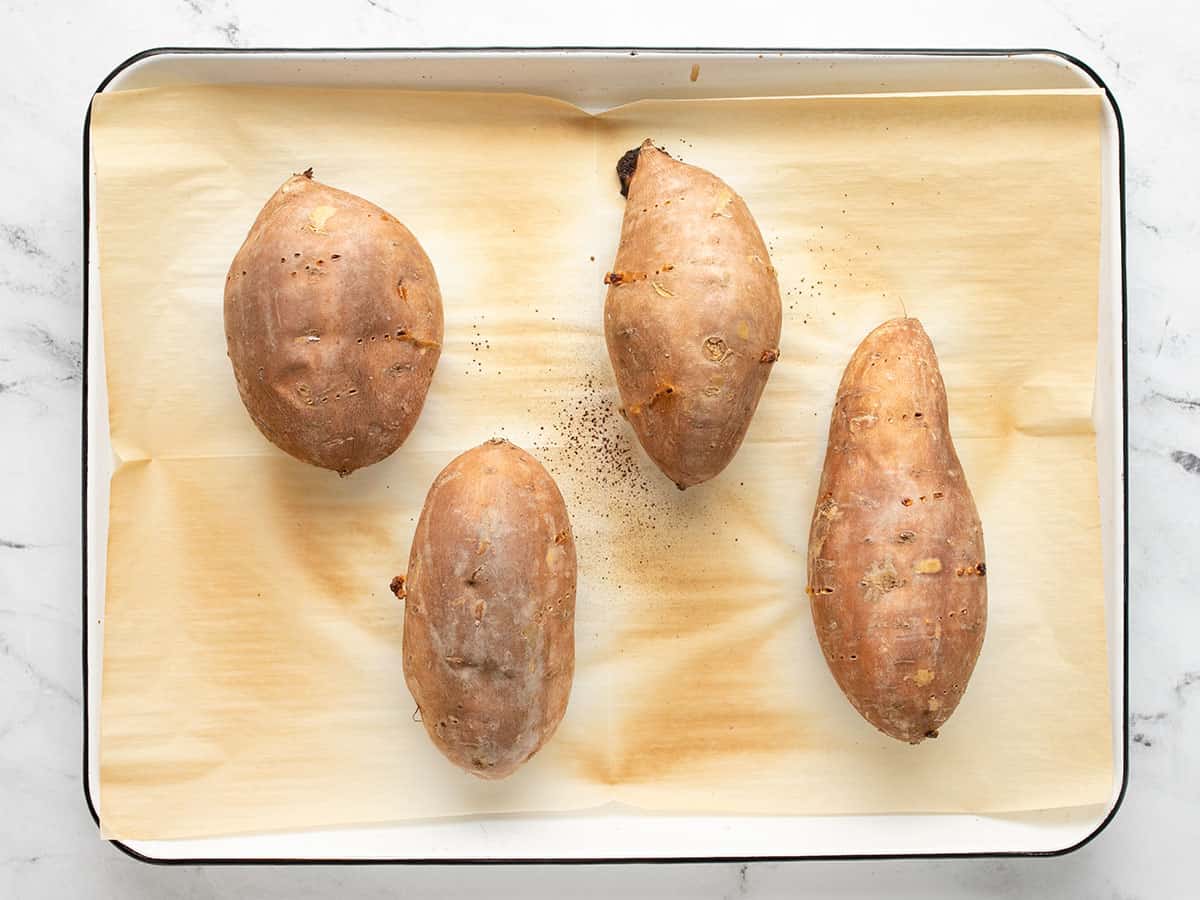 Baked sweet potatoes on the baking sheet.