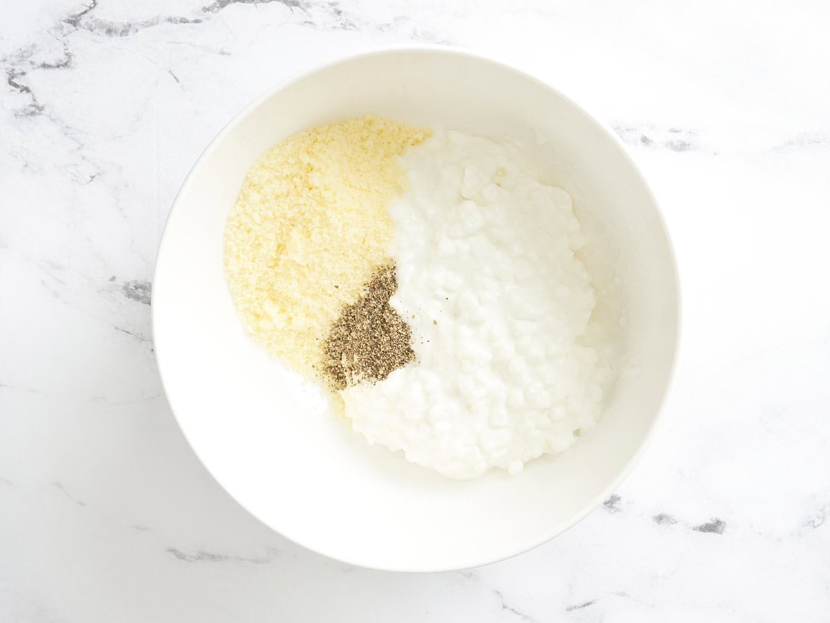 Cottage cheese, parmesan, and pepper in a bowl.