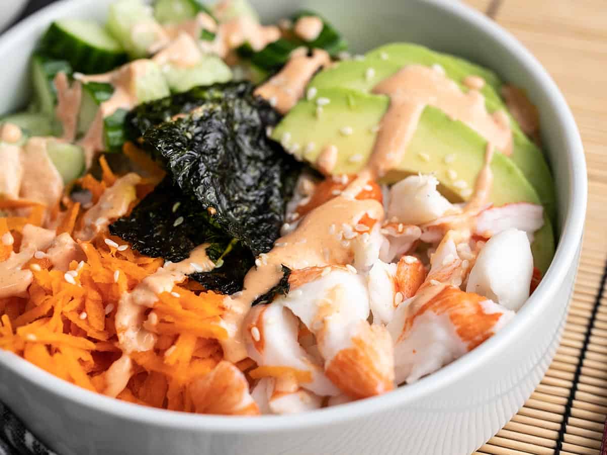 Homemade Sushi Bowls are a fast, easy, and inexpensive alternative to your favorite sushi bar. Get your sushi fix without spending a fortune. BudgetBytes.com Close up side view of a sushi bowl.