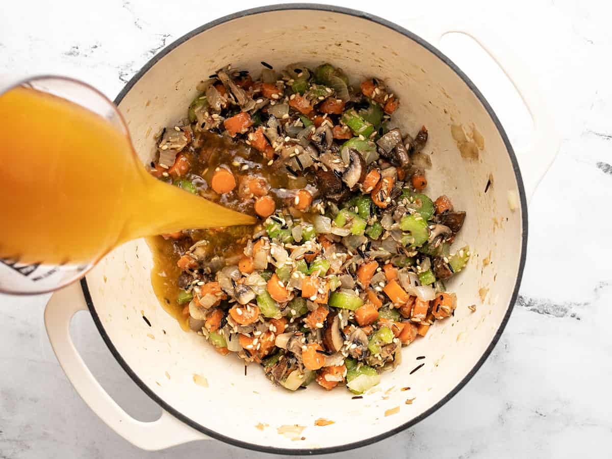 Vegetable broth being poured into the pot.