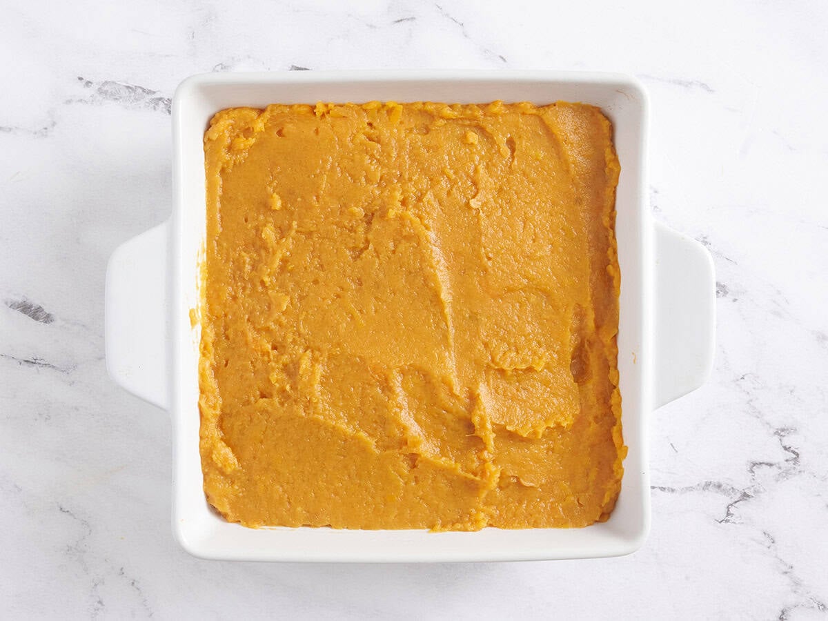 The filling for a sweet potato casserole in a baking dish.