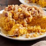 Sweet potato casserole on a plate with a fork.