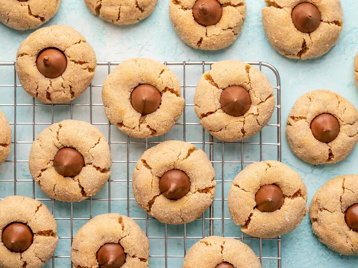 Peanut butter blossoms scattered on a cooling rack.