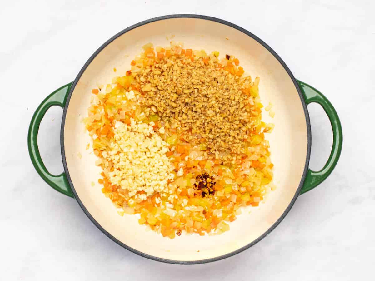 Garlic, walnuts, and red pepper added to the pot.