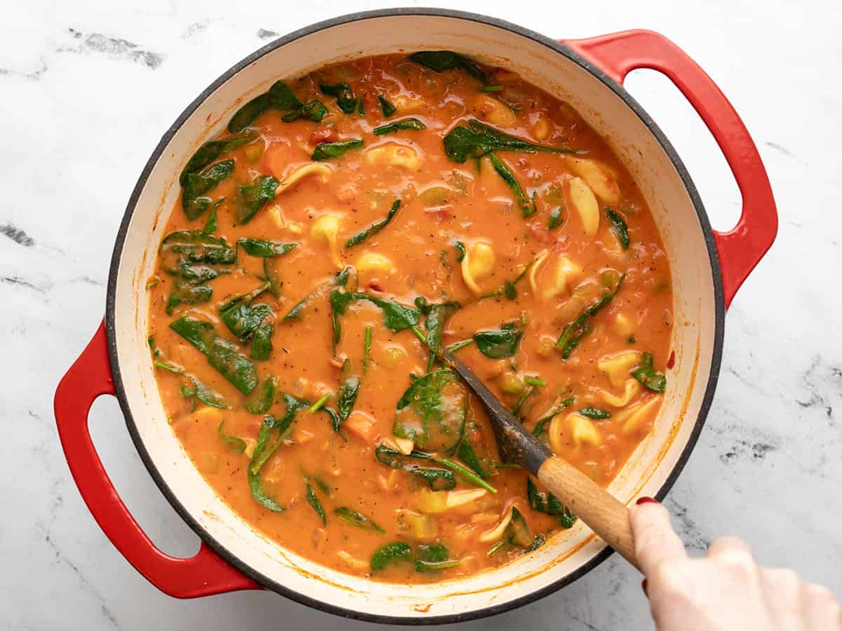 Finished soup in the pot being stirred.