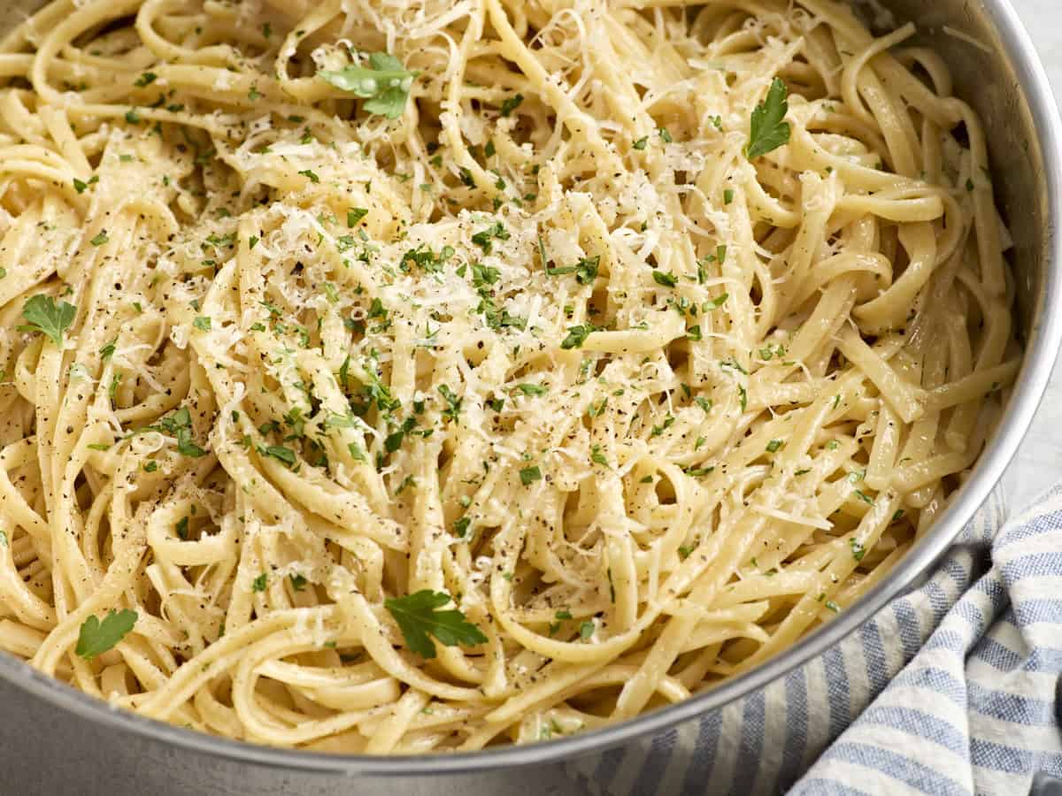 Side close up of a skillet of traditional fettuccine alfredo.