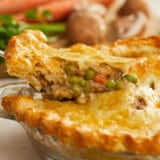 Side shot of a slice of vegetable pot pie being removed from the pie dish.