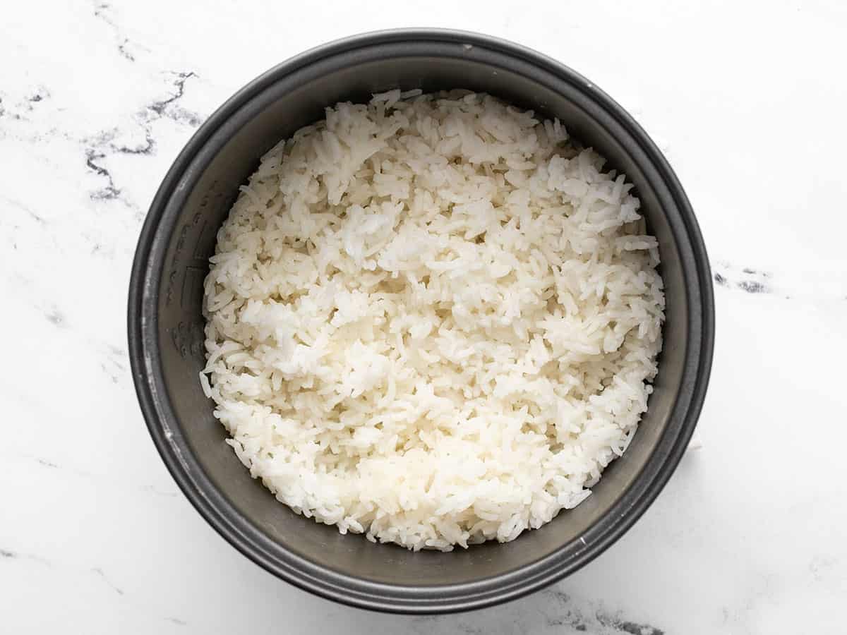Overhead shot of cooked rice in a rice maker.