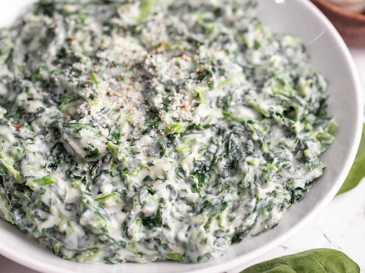 Close up side view of creamed spinach in a bowl.