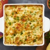 Overhead shot of scalloped potatoes in a white casserole dish.