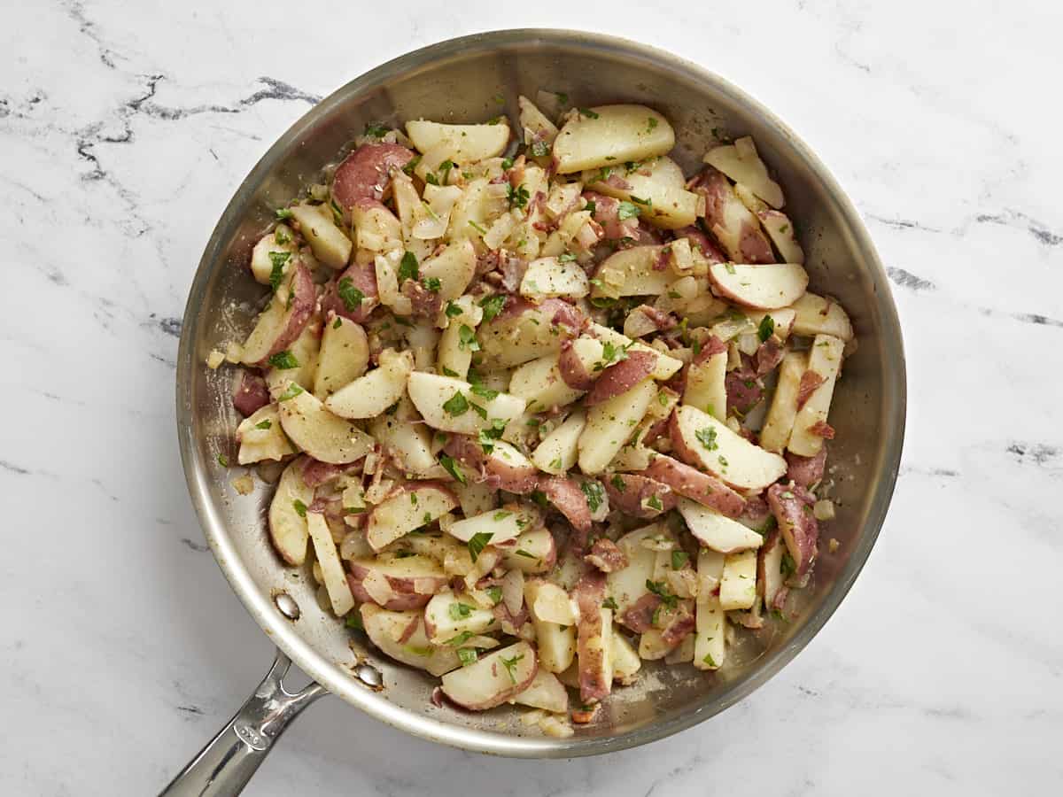 German Potato Salad is tossed in a deliciously sweet and tangy mayo-free dressing with bacon, mustard, and vinegar. Perfect for potlucks! BudgetBytes.com Finished German Potato Salad in the skillet.