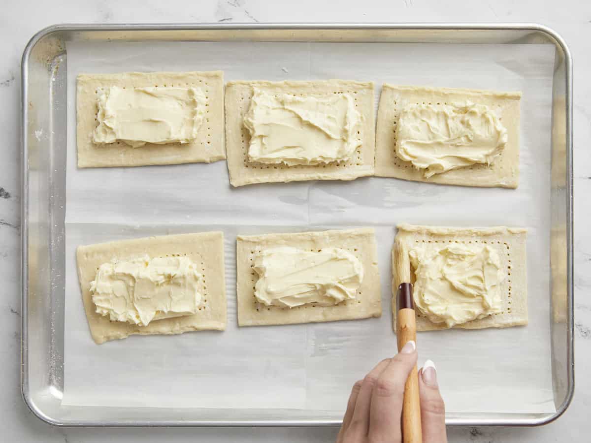 Overhead shot of egg wash being brushed on puff pastry.