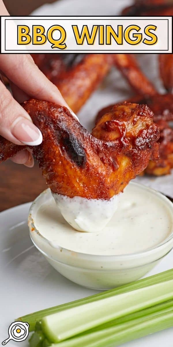 Side shot of BBQ Wing being dipped into bowl of ranch dressing.