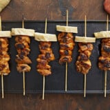 Overhead shot of Pinchos De Pollo on a black grill plate.