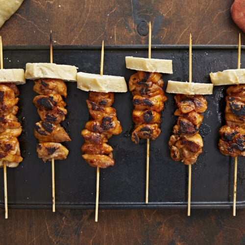 Overhead shot of Pinchos De Pollo on a black grill plate.