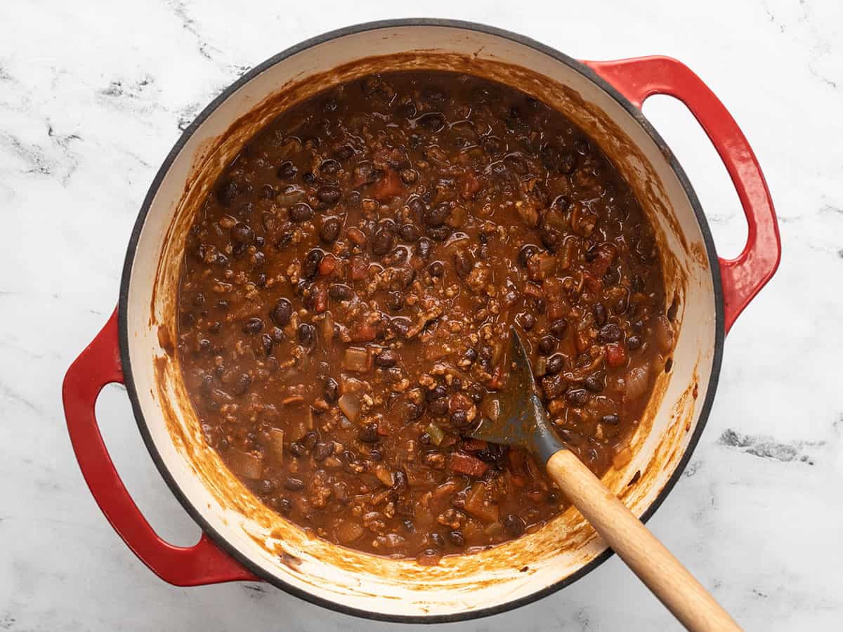 Simmered chili in the pot being stirred.