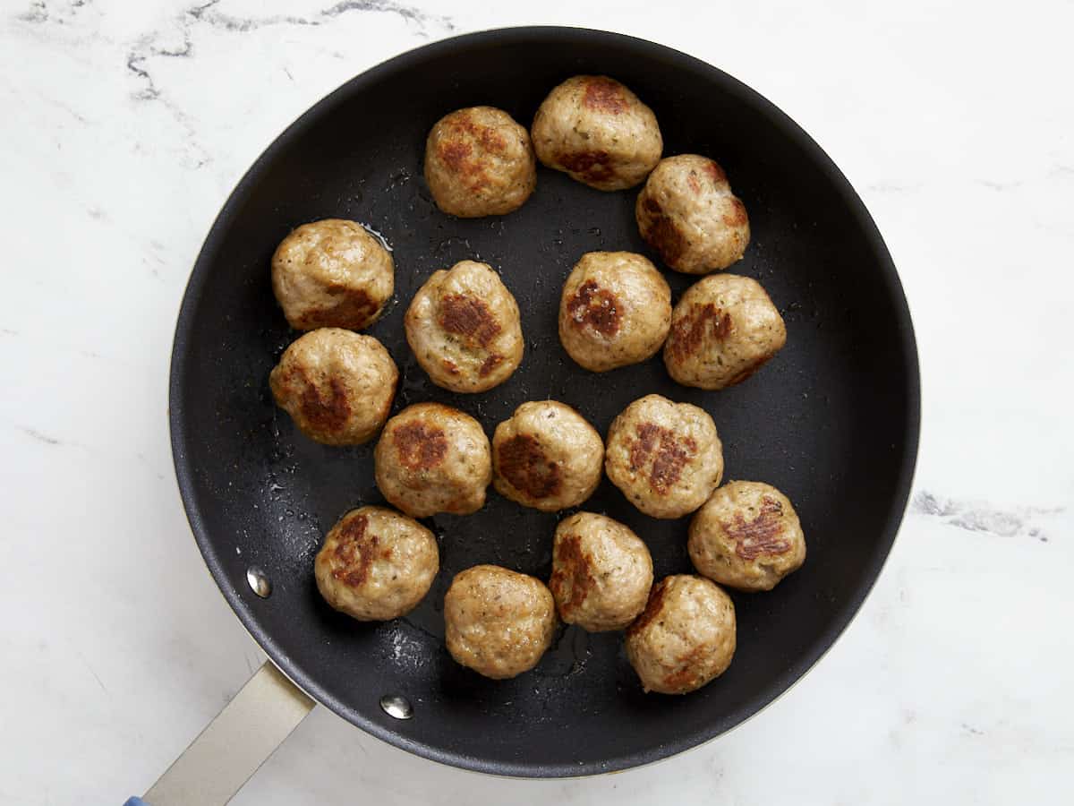 Turkey meatballs browned in a skillet.
