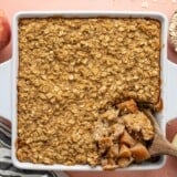 Overhead view of a casserole dish of apple cinnamon baked oatmeal with the corner being scooped out.
