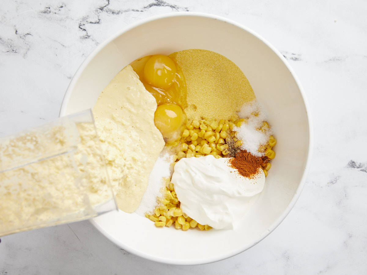 Other corn pudding ingredients added to the bowl with thawed corn.