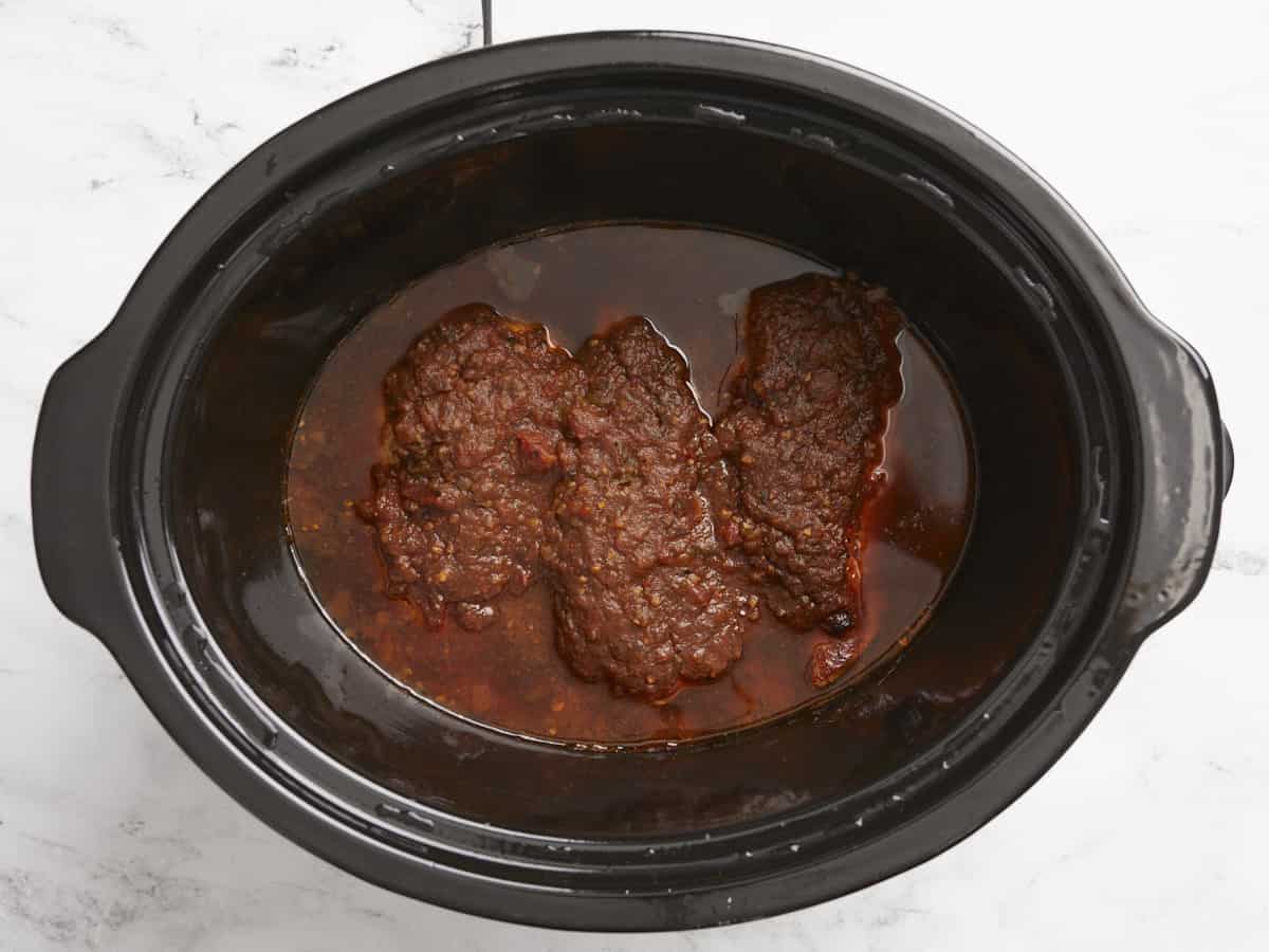 Cooked salsa chicken in the slow cooker before shredding.